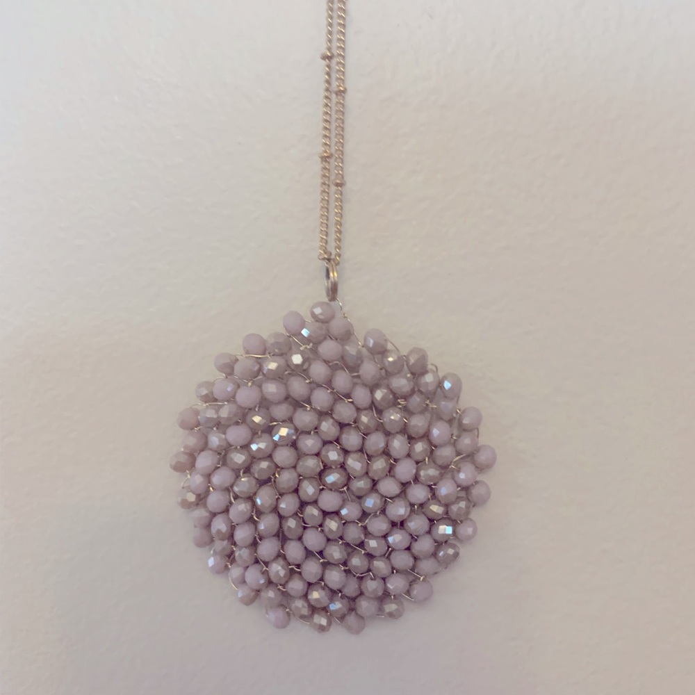 Gold necklace with pink embellishment.